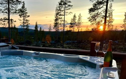 a hot tub with a bottle of wine and a wine glass at Idre Mountain Lodge dream with outdoor Jacuzzi ! in Idre