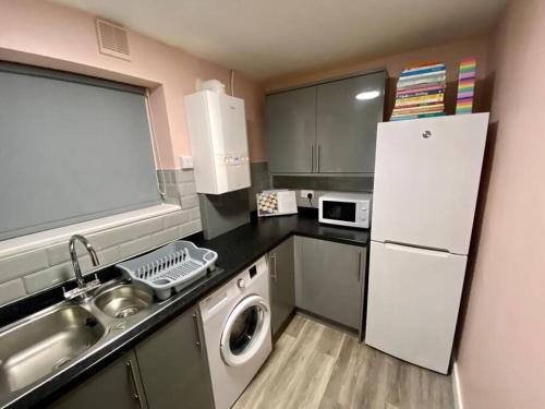 a kitchen with a sink and a white refrigerator at Bakers House - Contractor Suitable in Bentley