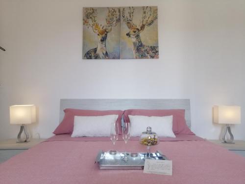 una camera con letto rosa e 2 lampade di B&B IL TULIPANO a Como