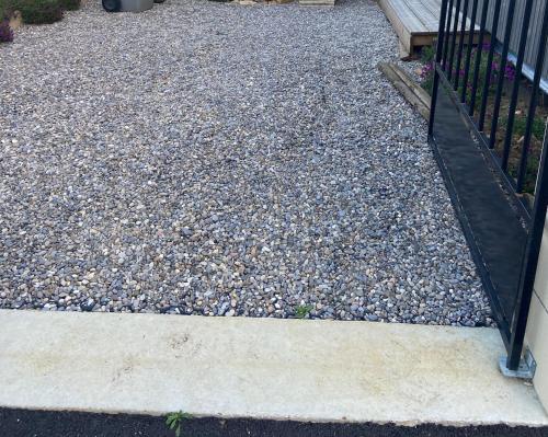a gravel yard with a black gate and a bunch of rocks at Studio atypique Le Mans in Le Mans