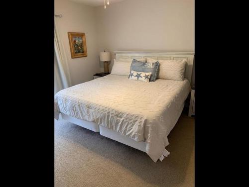 Un dormitorio con una cama blanca con almohadas. en Sealoft 4 Townhouse, en Myrtle Beach