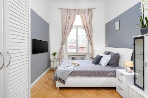 Habitación blanca con cama y ventana en Luxury 3KK Apt w/2KINGBeds 65”TV,Next Wenceslas Sq en Praga