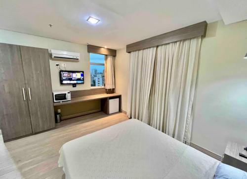 um quarto com uma cama e uma televisão em Iguassú Suítes - 602 em Nova Iguaçu