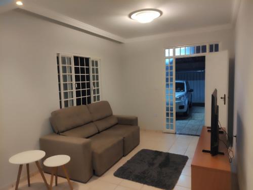 a living room with a couch and a tv at Casa ampla e linda com área de lazer in Uberlândia