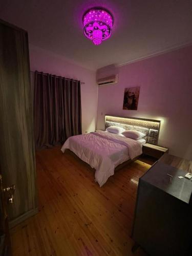 Fioletowa sypialnia z łóżkiem i różowym światłem w obiekcie Villa With A Private Garden In Beverly Hills w mieście 6th Of October (Miasto 6 października)