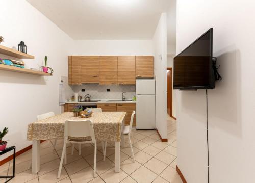 una cucina e una sala da pranzo con un tavolo e una televisione di Holiday Apartment - Brescia centro - PARCHEGGIO PRIVATO a Brescia