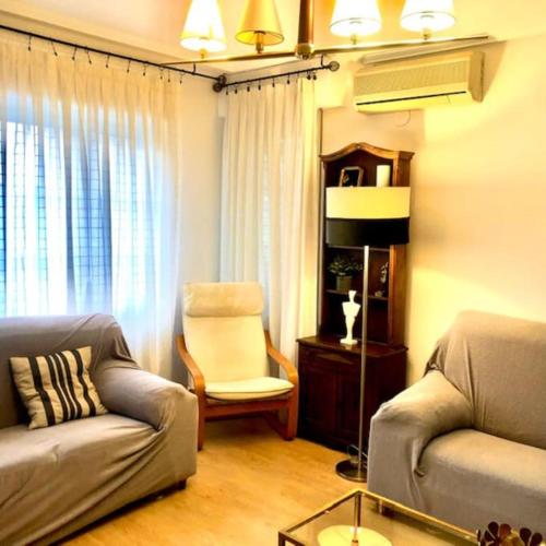 ein Wohnzimmer mit einem Sofa und einem Stuhl in der Unterkunft NUEVO! Con piscina a 2 minutos estación tren AVE. in Saragossa