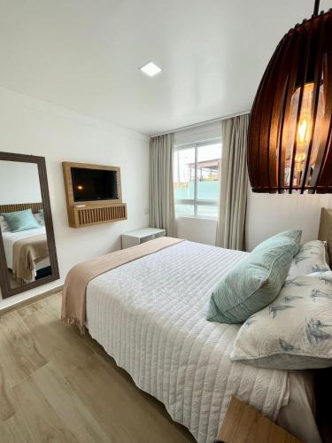 a bedroom with a large bed and a mirror at Beira a mar Ponta Negra Beach, Lovely Flat Natal RN in Natal