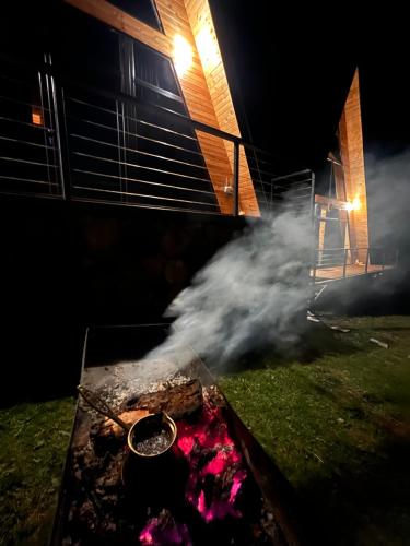 un incendie dans une cour la nuit avec de la fumée dans l'établissement Collodi Cottages, à Tba