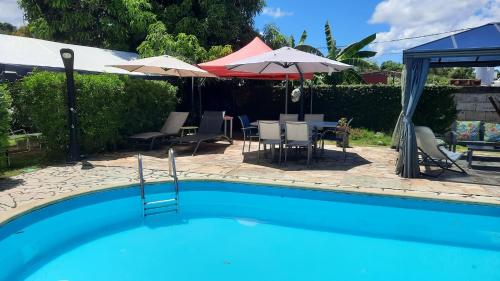 una piscina con mesa, sillas y sombrillas en villa do brazil en Ducos