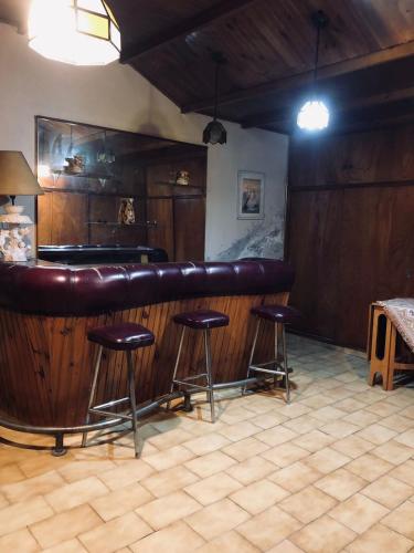un bar con taburetes de cuero marrón en una habitación en Casa Mirlo en Mendoza