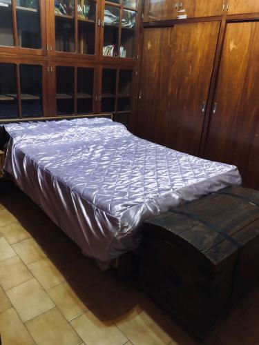 Cama en habitación con armario de madera en Casa Mirlo en Mendoza