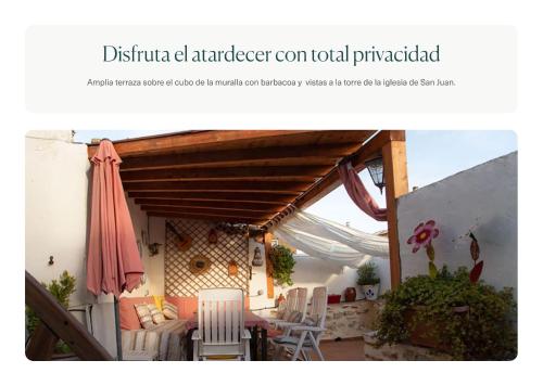 un patio con mesa, sillas y sombrilla en Casa La Real en Arévalo