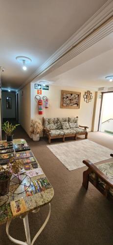 uma sala de estar com um sofá e mesas em Pousada Araucária em Campos do Jordão
