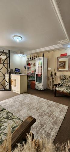 a living room with a refrigerator and a couch at Pousada Araucária in Campos do Jordão