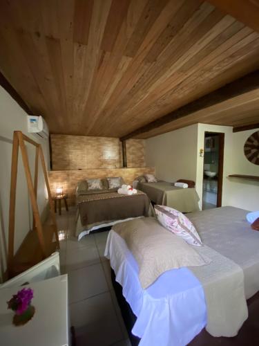 a bedroom with two beds and a wooden ceiling at Pousada Natureza Viva in Itacaré