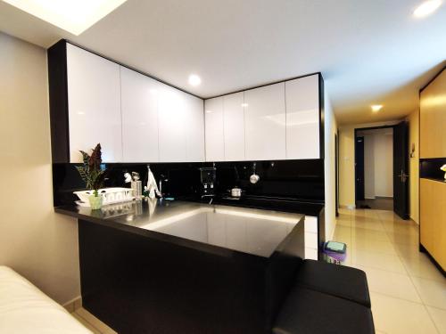 a kitchen with a large sink and white cabinets at TopGenting SkyColdPondSuite @GrdIonDelmn in Genting Highlands