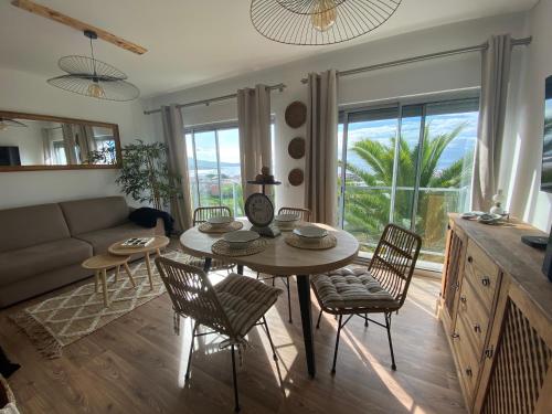 a living room with a table and chairs and a couch at Apartamento Raposo in São Roque