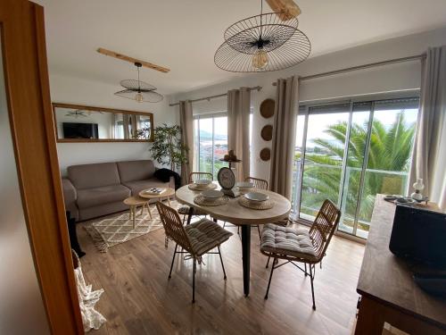 a living room with a table and chairs and a couch at Apartamento Raposo in São Roque