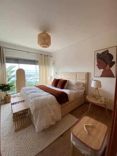 a bedroom with a large bed and a large window at Apartamento Raposo in São Roque