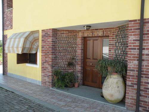 a brick building with a door and plants in front of it at B&B Da Levi Piana Del Sole in Rivalta Bormida