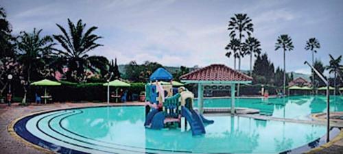 eine Wasserrutsche in einem Pool in einem Resort in der Unterkunft Villa Miky Kota Bunga Puncak Cianjur Bogor in Cinengangirang