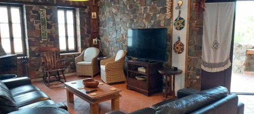 a living room with a couch and a flat screen tv at FIKARDOU ALMOND PARK in Phikardhou