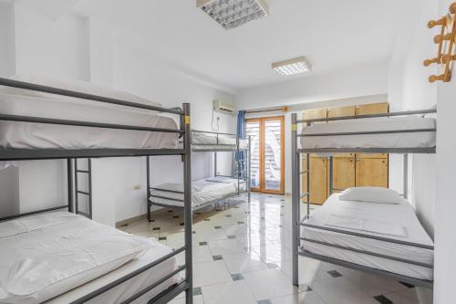 a dorm room with three bunk beds in it at Hostel Hasta La Vista in Sarandë