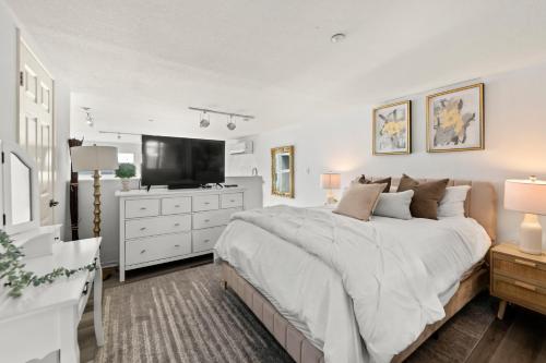 a bedroom with a large bed and a flat screen tv at The Italian Retreat, Little Italy in San Diego