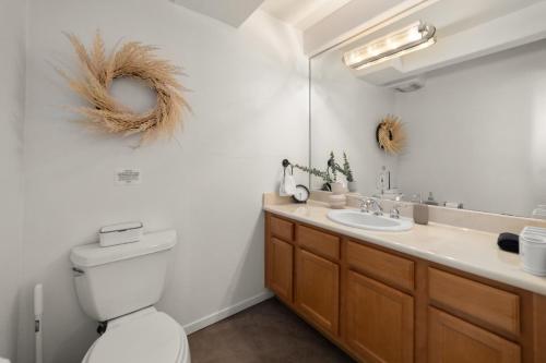 uma casa de banho com um WC, um lavatório e um espelho. em The Italian Retreat, Little Italy em San Diego