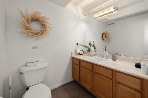 a bathroom with a toilet and a sink and a mirror at The Italian Retreat, Little Italy in San Diego