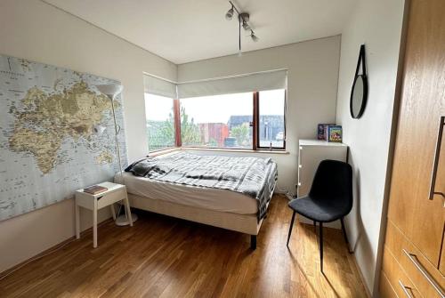 a bedroom with a bed and a window and a chair at Spacious Family friendly house in the Reykjavik in Reykjavík