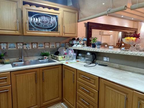 a kitchen with wooden cabinets and a sink and a mirror at بيت الاحلام للسكن الراقي in Cairo