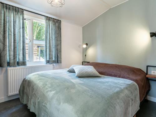ein Schlafzimmer mit einem großen Bett und einem Fenster in der Unterkunft De Tortelduif in Hulshorst