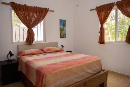 巴亞希貝的住宿－Villa Caribe，一间卧室设有一张床和两个窗户。