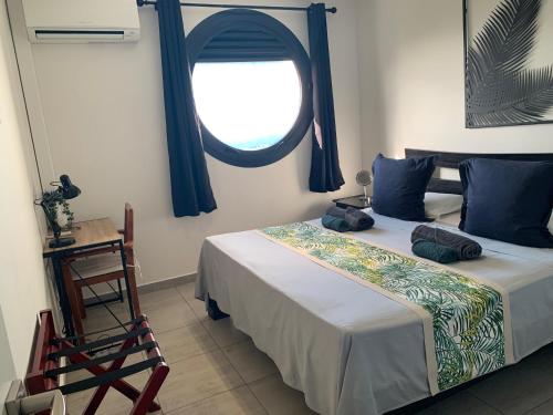 a bedroom with a large bed with a window at Kaili Ocean view luxury 2BR AC throughout Fiber Wifi & Pool in Papeete