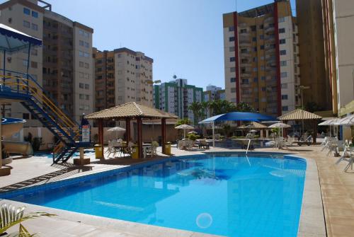 a large blue swimming pool with buildings in the background at APT. 2/4 - Prive das Thermas I - 7 piscinas termal - Apclube Tur in Caldas Novas