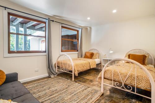 a bedroom with two beds and a couch and a window at The Panoramic Tree View Home in Melbourne City in Melbourne