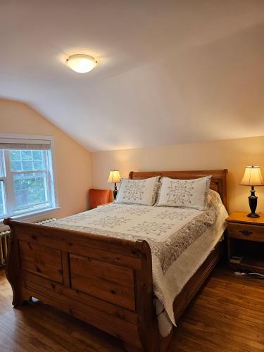 een slaapkamer met een groot houten bed met 2 lampen bij Comfy Stay - Close to Everything in Halifax