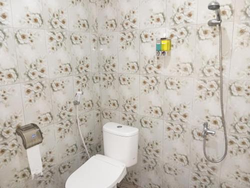 a bathroom with a toilet and a shower at WL GUESTHOUSE in Labuan Bajo