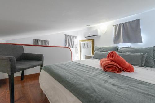 um quarto com uma cama com uma toalha vermelha em Duplex PLAZA MAYOR by MONARO***** em Madri