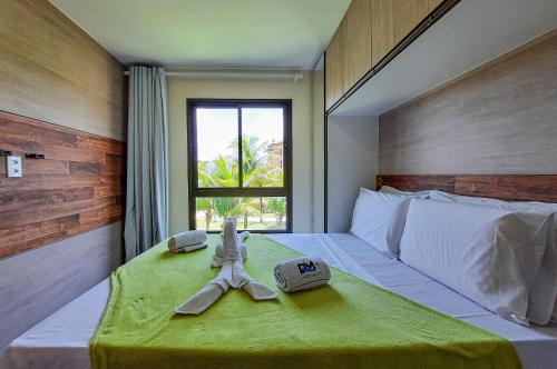um quarto com uma cama com um cobertor verde e uma janela em VG Sun Cumbuco 4 Pessoas Nascente WiFi em Cumbuco