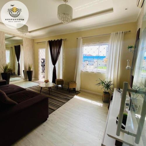 - un salon avec un canapé et une grande fenêtre dans l'établissement Hospedagem Praia Central, à Navegantes