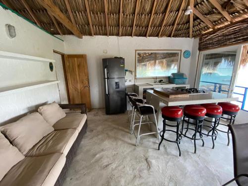 a living room with a couch and a kitchen with a counter at Hostal Coral Blue in Rincón