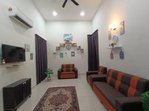 a living room with two couches and a flat screen tv at Homestay Teacher,Perak, Gerikmist in Gerik