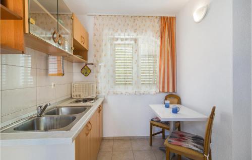 eine kleine Küche mit einem Waschbecken und einem Tisch in der Unterkunft Beautiful Apartment In Split With Wi-fi in Split