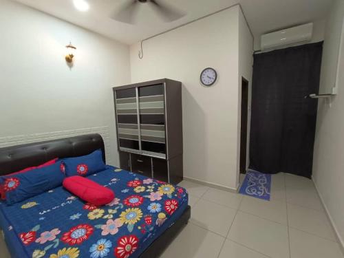 a bedroom with a bed and a clock on the wall at Homestay Teacher,Perak, Gerikmist in Gerik