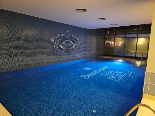 a large swimming pool in a room with a wall at TAKSiM PERFECT RESiDENCE, 3 BEDROOMS, 140 M2, POOL GYM SAUNA ACCESS in Istanbul