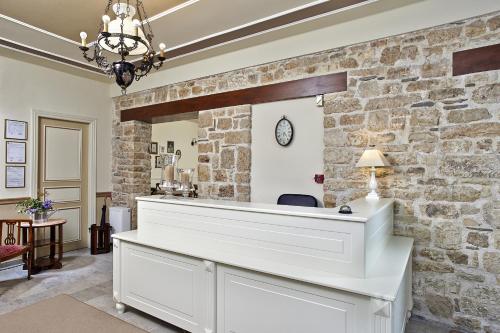 a stone wall with a reception desk in a room at Hotel Kastro in Ioannina