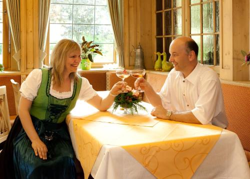 a man and woman sitting at a table with glasses of wine at Hotel - Landgasthof Rebstock in Nimburg